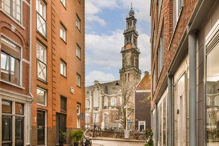 a city street with buildings and a clock tower in the background, as seen from an alley way on a sunny dayの写真素材