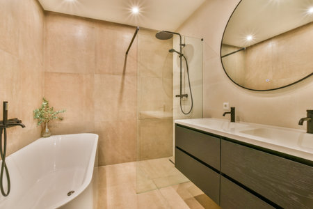a modern bathroom with beige tiles on the walls, and a large round mirror over the bathtub in the cornerの写真素材