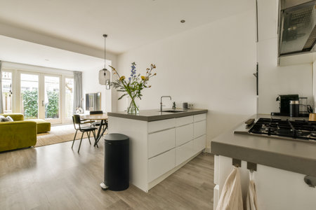 a kitchen and dining area in a house with wood floors, white walls and doors open to the living roomの写真素材