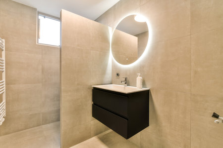 a bathroom with a mirror above the sink and toilet paper on the wall next to it is a towel rackの写真素材