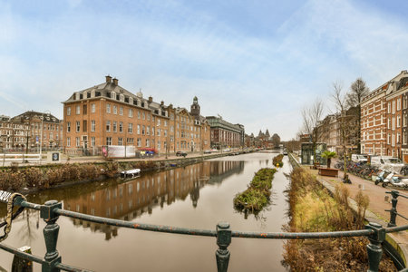 Amsterdam, Netherlands - 10 April, 2021: a canal with buildings in the background and water on both sides, taken from an overpassed bridge across itのeditorial素材