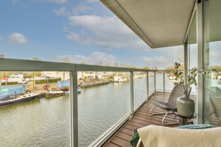 a balcony with some boats in the water and buildings on the other side of the river behind it, as...
