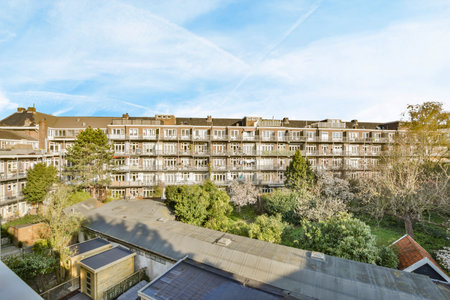 an apartment complex with trees and buildings in the foregrounded area, taken from a drones...