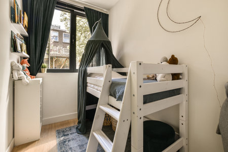 a kids room with two bunk beds and a large window that looks out onto the street in the backgroundのeditorial素材