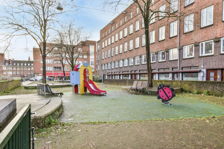 an empty playground in the middle of a residential area with children playing on swings, slides and...