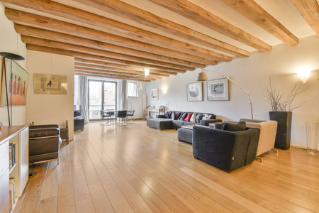 Amsterdam, Netherlands - 10 April, 2021: a living room with wood flooring and exposed beams on the ceiling above it is a couch, coffee table, chair, tvのeditorial素材