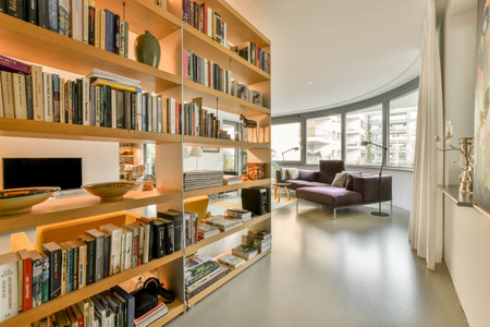 a living room with many books on the shelves and a couch in the corner next to the book shelf is...