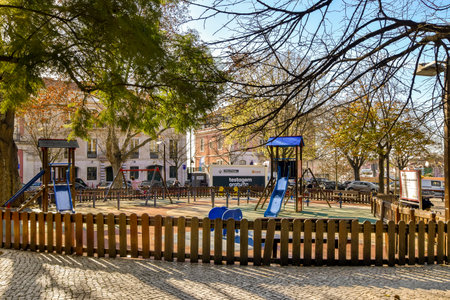 an outdoor play area in the middle of a city with lots of trees and childrens playgrounds on both sidesのeditorial素材