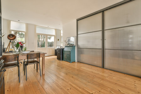 a living room with wood flooring and sliding glass doors that open up to the dining area in this homeのeditorial素材