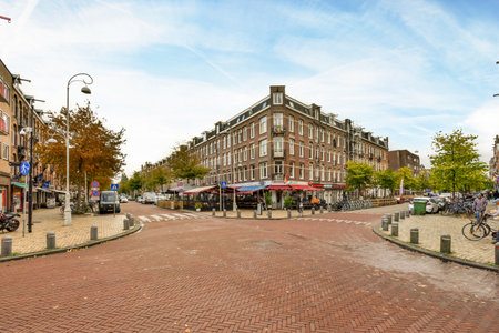 a city street with people walking and bikes parked on the sidewalks in front of shops, restaurants, and storesのeditorial素材