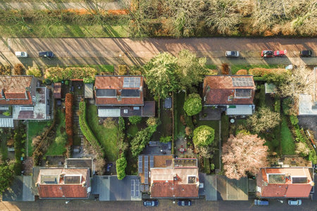Amsterdam, Netherlands - 10 April, 2021: an aerial view of houses in the suburbs, with cars parked on the street and trees growing all around themのeditorial素材