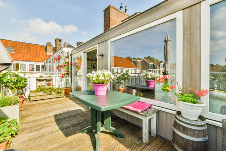 Amsterdam, Netherlands - 10 April, 2021: a balcony with potted flowers on the table and two chairs in front of the house, taken from outsideのeditorial素材