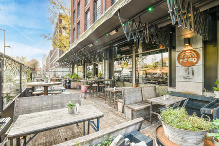 an outdoor patio with tables, chairs and potted plants on the table in front of the restaurants entranceのeditorial素材