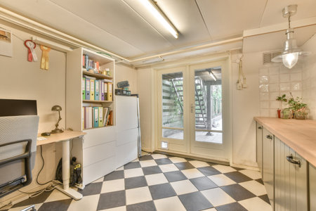 a kitchen with black and white checkered tiles on the floor next to an open door that leads to a patioのeditorial素材