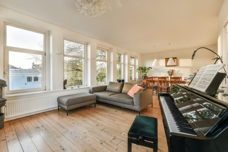Amsterdam, Netherlands - 10 April, 2021: a living room with a piano in the middle and a couch on the other side of the room is emptyのeditorial素材