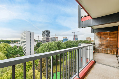 Amsterdam, Netherlands - 10 April, 2021: a balcony with trees and buildings in the background, as seen from an apartment window looking out onto the streetのeditorial素材