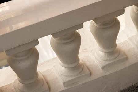 some white vases on top of a stone wall with black and white paint in the background is blurryのeditorial素材