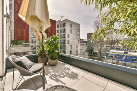Amsterdam, Netherlands - 10 April, 2021: an outside area with chairs, umbrellas and plants on the balcony looking out to the cityscapeaのeditorial素材