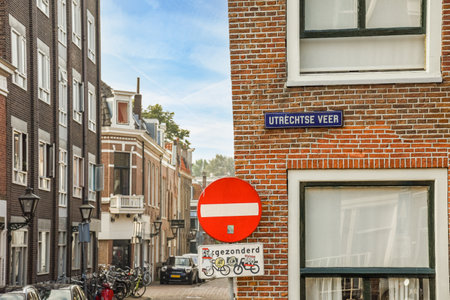 a street sign on the side of a brick building with bicycles parked in front of it and two buildings behindのeditorial素材