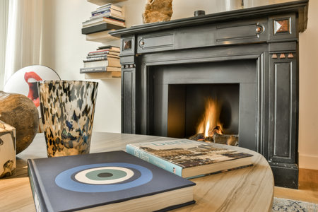 an animal sitting on a table in front of a fire place with books and a vase next to the fireplaceのeditorial素材