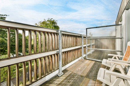 Amsterdam, Netherlands - 10 April, 2021: a wooden deck with white chairs and trees in the background on a sunny day at a blue sky is visibleのeditorial素材