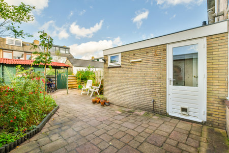 Amsterdam, Netherlands - 10 April, 2021: a back yard with some plants and flowers in the fore -...