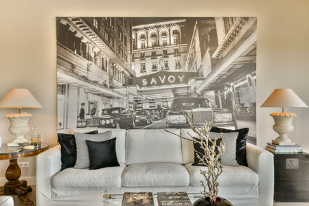 an old building is on the wall behind the couch and coffee table in this living room has white sofas with black pillowsのeditorial素材