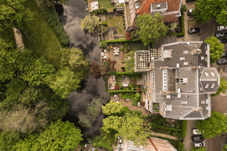 an aerial view of a house in the middle of a residential area with lots of trees and houses on both sidesのeditorial素材