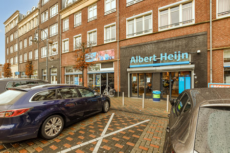 Amsterdam, Netherlands - 10 April, 2021: a car parked in front of an older - hin store on the side of a bricked street with cars parked nearbyのeditorial素材