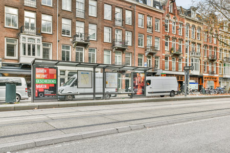 Amsterdam, Netherlands - 10 April, 2021: a city street with cars parked on the side of the road and buildings in the background, along an urban streetのeditorial素材