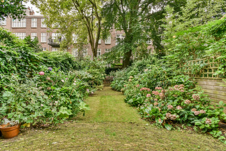 Amsterdam, Netherlands - 10 April, 2021: a garden with lots of plants and flowers in the fore - image is taken from an angle to show how its goingのeditorial素材