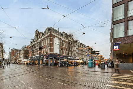 Amsterdam, Netherlands - 10 April, 2021: a city street with people walking on the sidewalks and cars driving down the road in front of some buildingsのeditorial素材