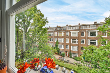Amsterdam, Netherlands - 10 April, 2021: a view from a window with flowers in the foreground and...