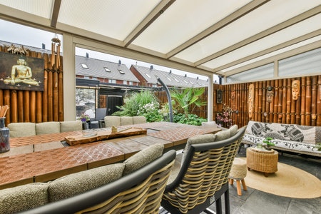 an outdoor living area with couches, tables and chairs in the photo is taken from outside to show how its goingのeditorial素材