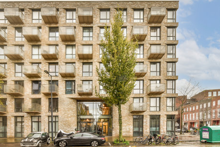 Amsterdam, Netherlands - 10 April, 2021: an apartment building with cars parked on the street next...