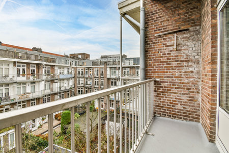 Amsterdam, Netherlands - 10 April, 2021: a balcony with brick walls and balks on the left side, there is a blue sky in the backgroundのeditorial素材