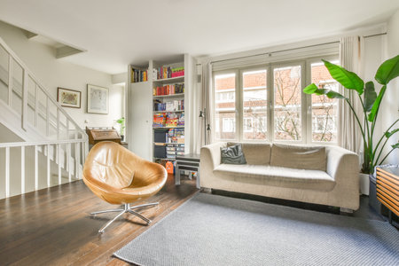 Amsterdam, Netherlands - 10 April, 2021: a living room with a couch, chair and bookshel in the...