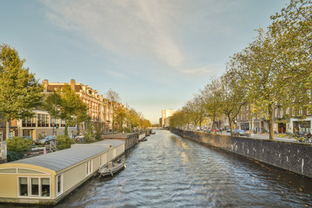 a canal with houses on both sides and boats in the middle one boat is moving down its sideのeditorial素材