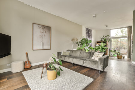 Amsterdam, Netherlands - 10 April, 2021: a living room with wood flooring and large windows looking out onto the backyard area, which is very well furnishedのeditorial素材