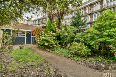 Amsterdam, Netherlands - 10 April, 2021: some trees and bushes in front of an apartment building on...