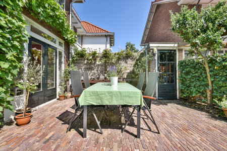 a table and chairs on a wooden deck in the backyard with green plants growing around it, surrounded by ivysのeditorial素材