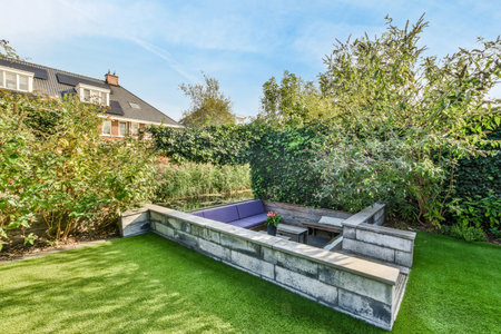 a backyard area with an outdoor fire pit in the middle, surrounded by lush green trees and bushes on either sideのeditorial素材