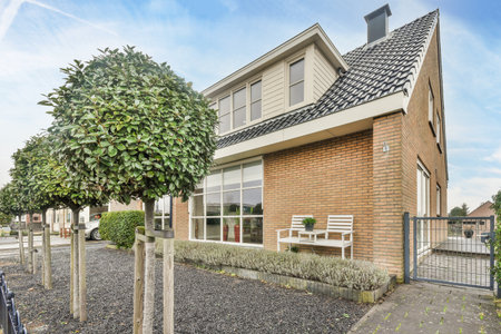 Amsterdam, Netherlands - 10 April, 2021: a house that is in the middle of an urban neighborhood with trees and bushes growing on either side of itのeditorial素材