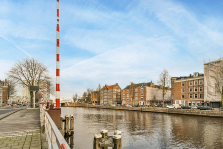 a canal with buildings and boats in the background, taken from a boat on the waters edge there is a blue skyのeditorial素材