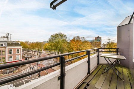 a balcony with some buildings in the background and a bird flying overhead over the railing on the...