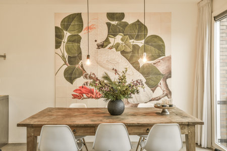 Amsterdam, Netherlands - 10 April, 2021: flowers in a vase on a wall above a dining table with four white chairs and a large painting behind itのeditorial素材