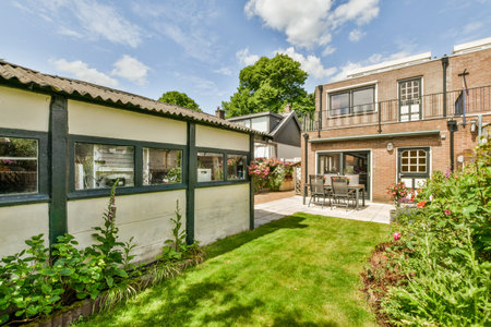 a house in the middle of a garden with flowers and plants growing on the side of the house there is...