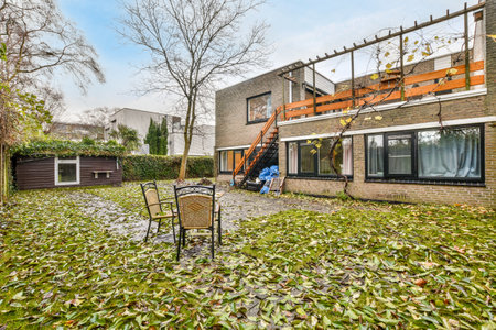 a backyard with some leaves on the ground and an outdoor dining area in the back, there is a fire pitのeditorial素材