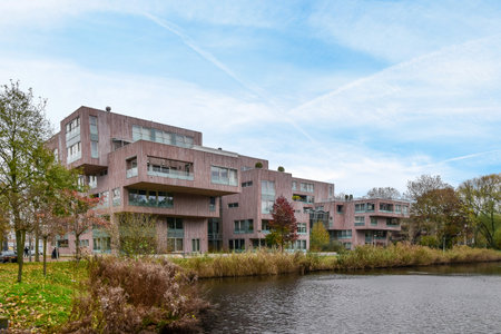 some buildings on the side of a body of water with trees and bushes in the foreground area behind itのeditorial素材