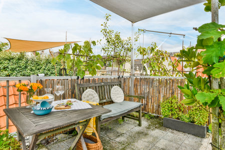 an outdoor dining area with plants and pots on the table in front of a wooden fenced back yard
